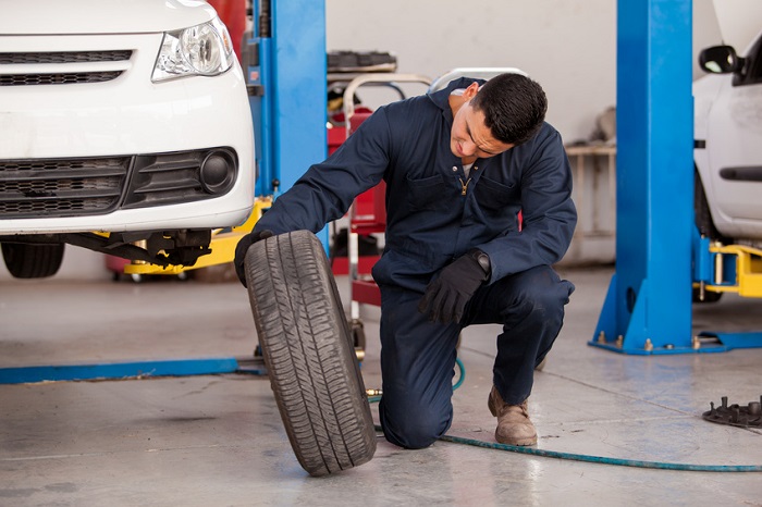 Chevy service technician inspecting a tire