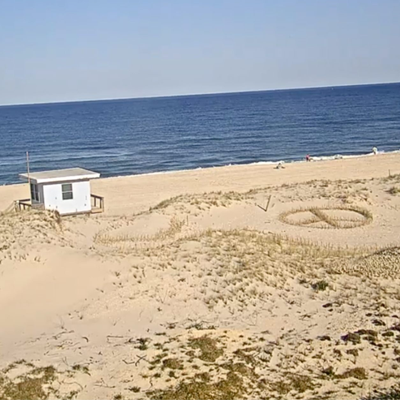 A sandy beach with a peace sign drawn in it